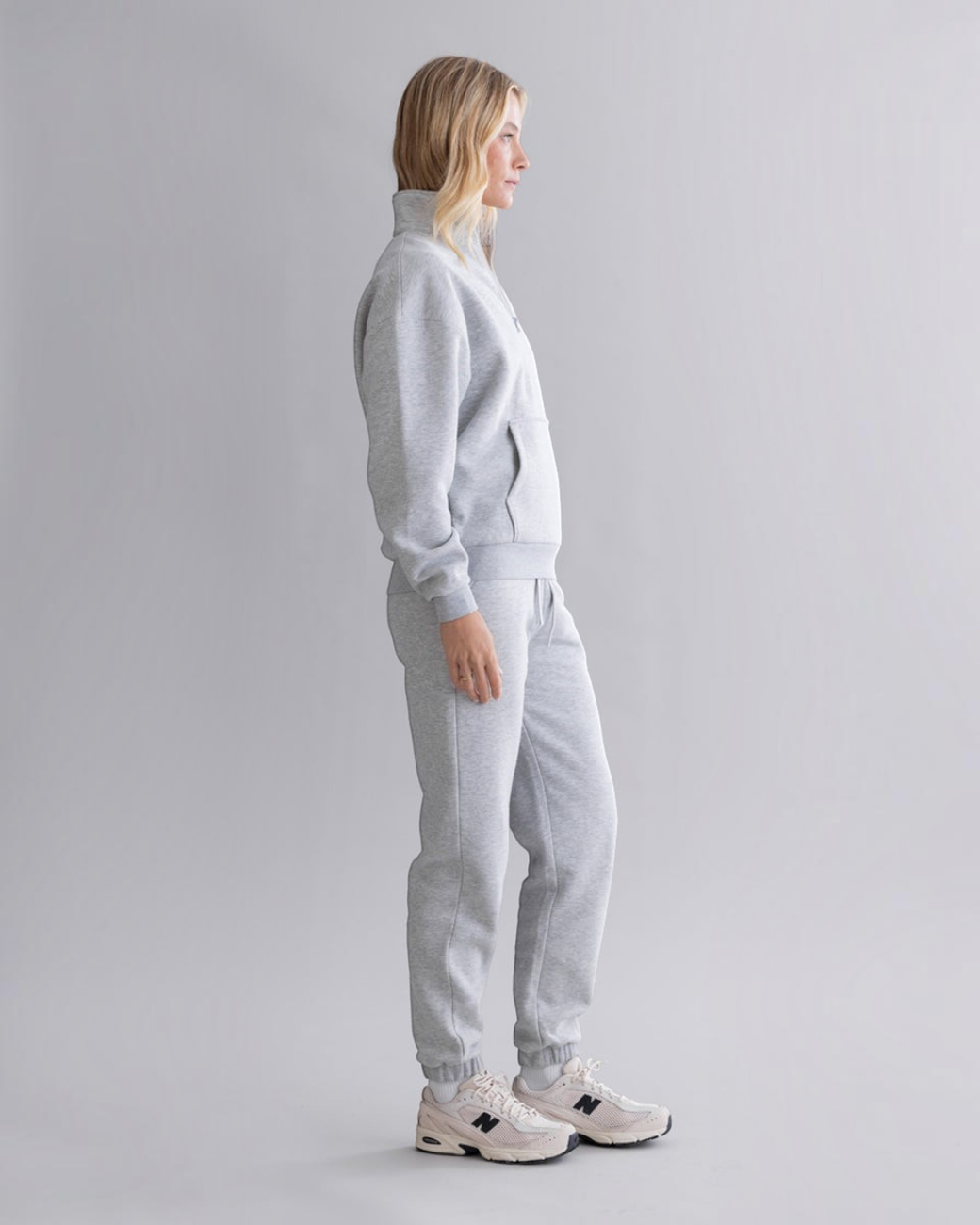greenyogashop graue Cuff Sweatpants aus Baumwollmix mit elastischen Bündchen an einer Frau in Seitenansicht