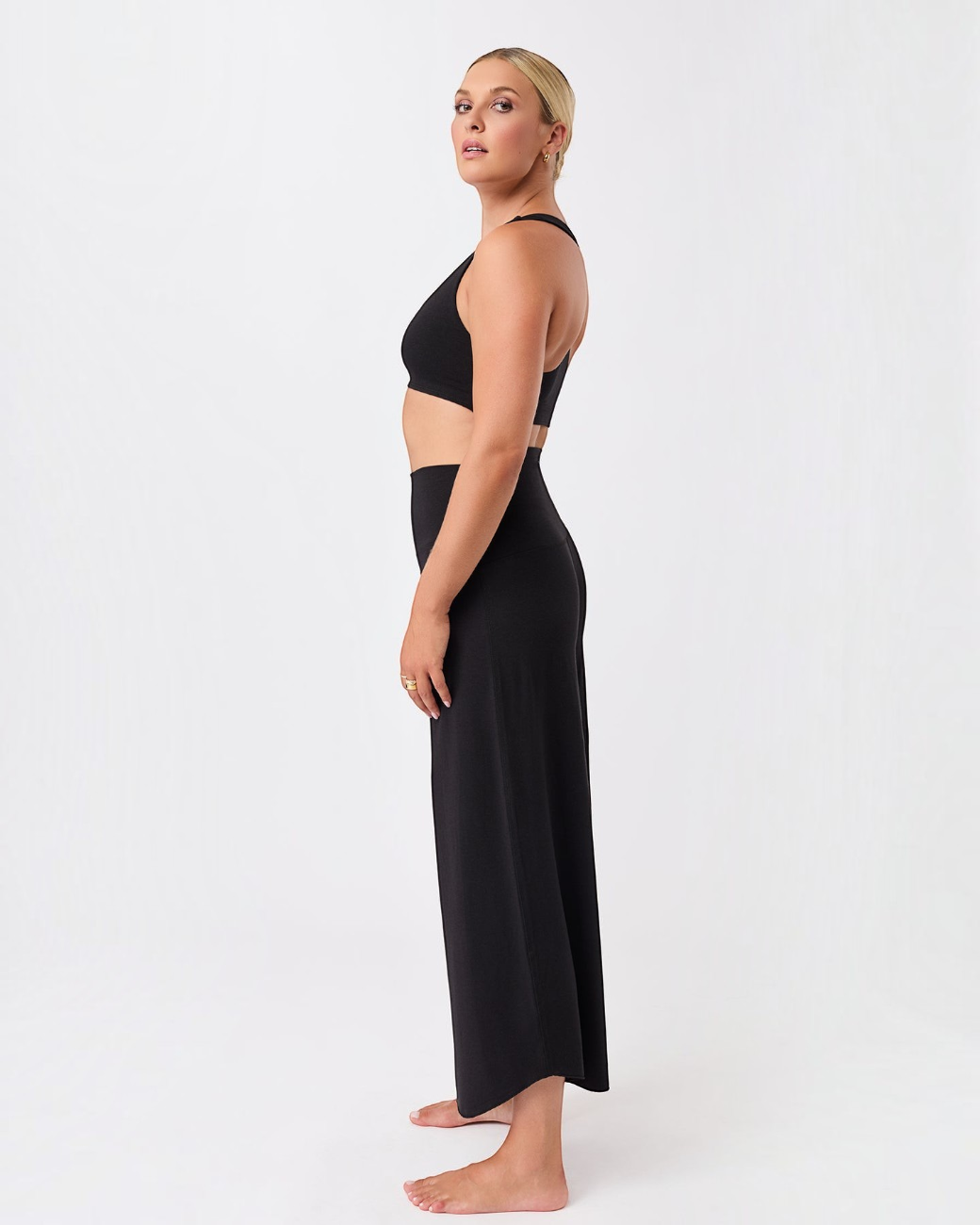 Model trägt schwarze greenyogashop Hose Roll Over Tulip in 7/8 Länge aus weichem Lyocell-Mix für Yoga und Freizeit