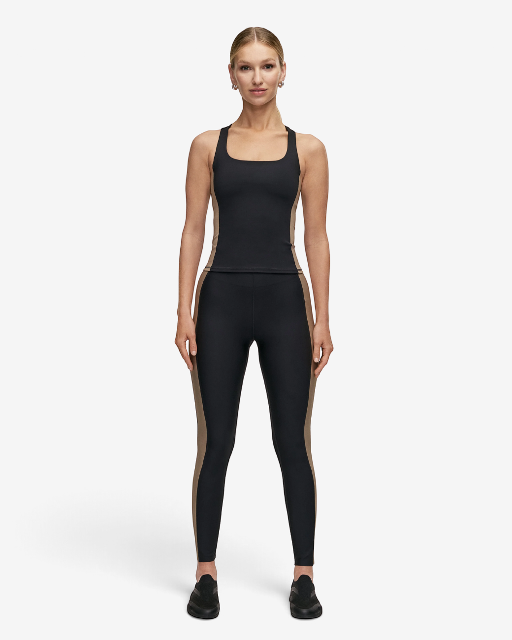 Model trägt greenyogashop Shaped Block High Waist Leggings in Schwarz mit kontrastfarbenen Seiteneinsätzen