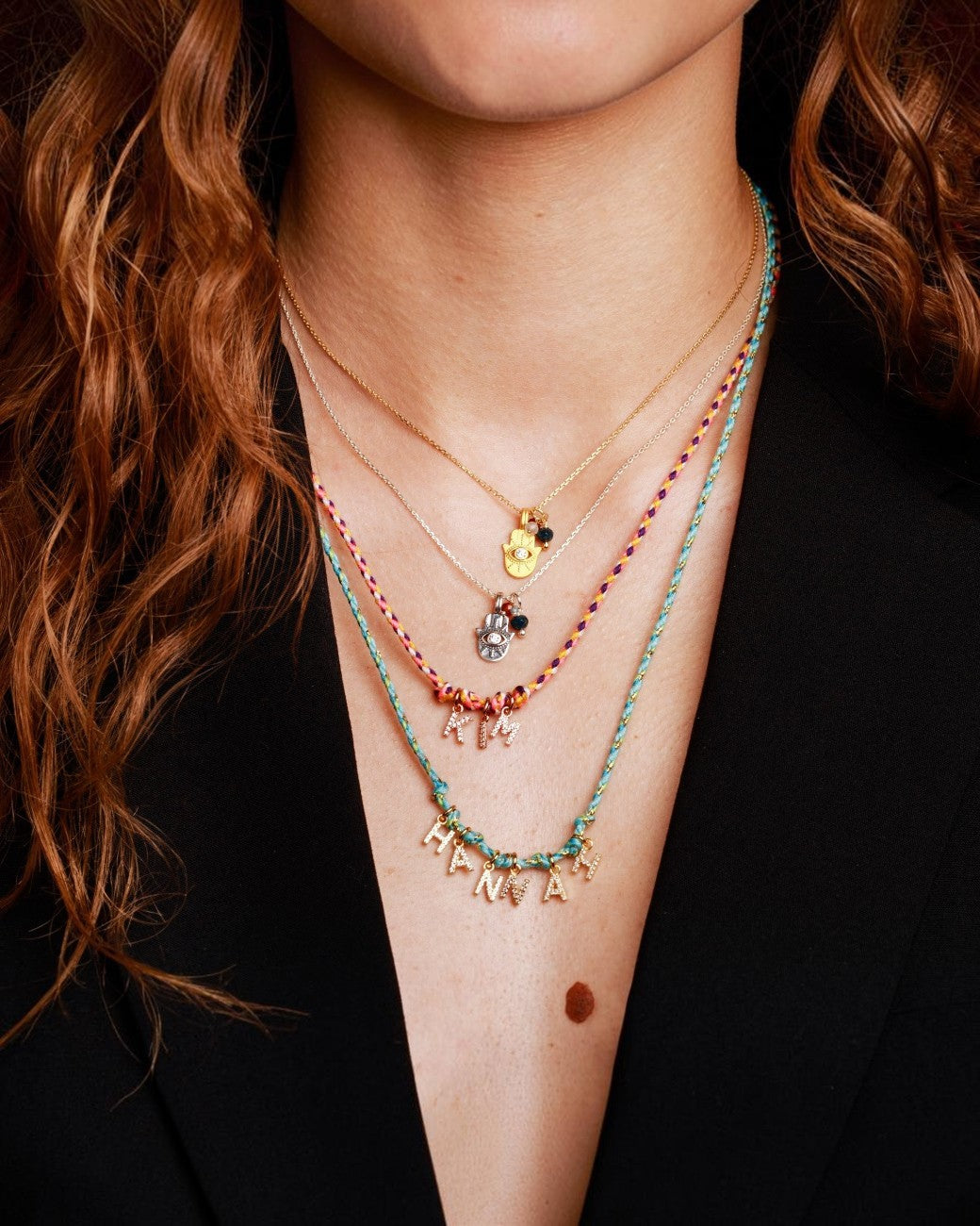 greenyogashop Schutzkette Hamsa aus Sterlingsilber mit Edelsteinen und bunten Textilbändern am Hals einer Frau