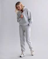 greenyogashop Cuff Sweatpants in Grau Melange mit elastischem Bund und Bündchen an einer Frau im Studio