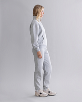 greenyogashop graue Cuff Sweatpants aus Baumwollmix mit elastischen Bündchen an einer Frau in Seitenansicht
