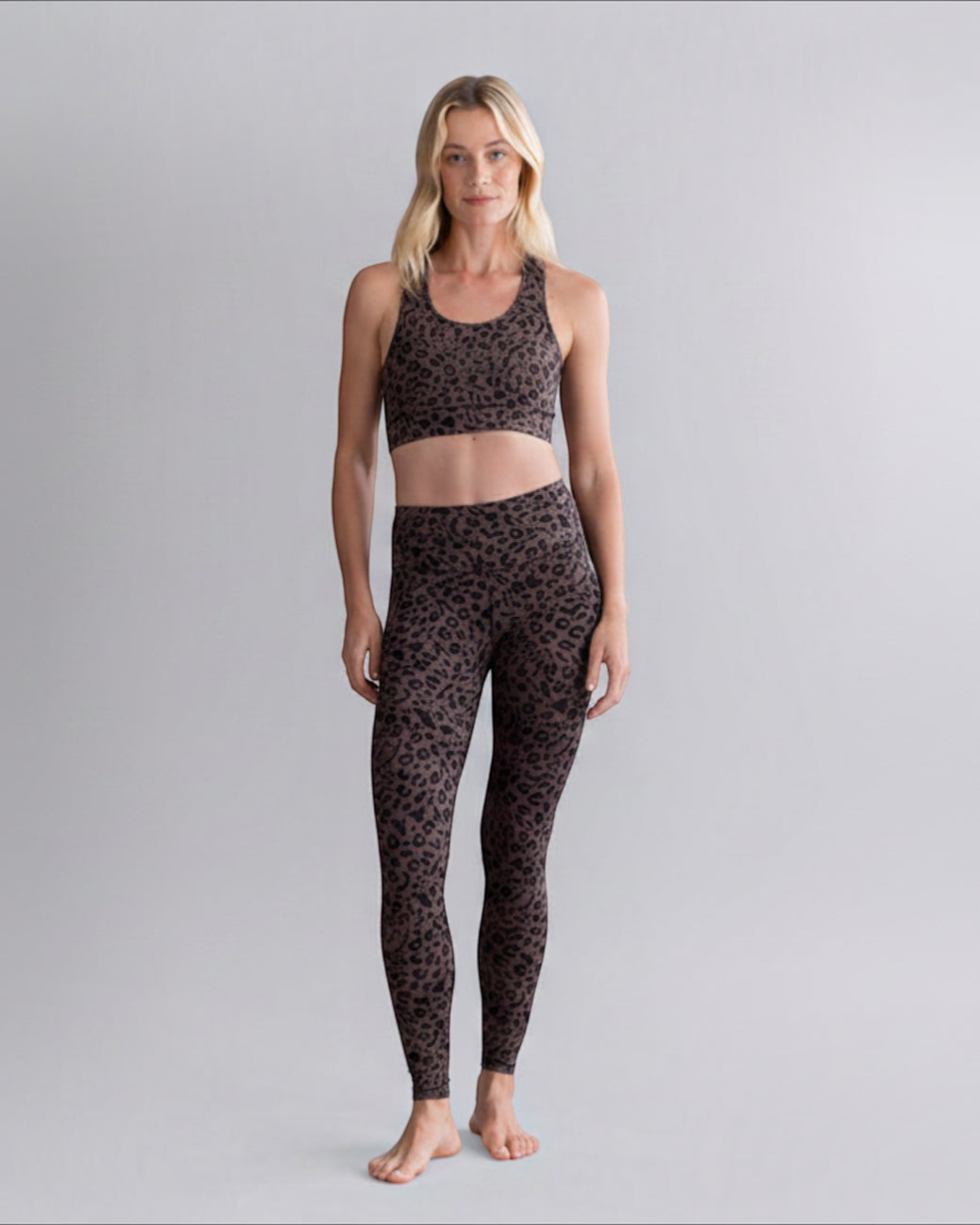 Model trägt greenyogashop Leggings Mono Leo in Soft Brown mit Leopardenmuster, hohem Bund und Sport-BH