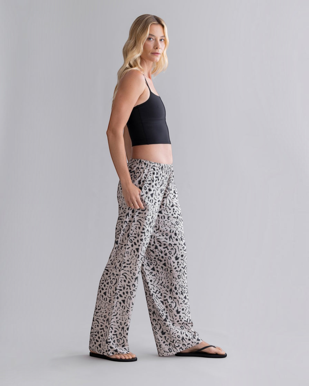 Model trägt greenyogashop Sommerhose aus Viskose in Oatmeal mit Leo-Muster, weitem Schnitt und Seitentaschen.