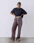 Model trägt taupefarbene greenyogashop Lounge-Trackpants mit weitem Bein, elastischem Bund und Herringbone-Seitenstreifen