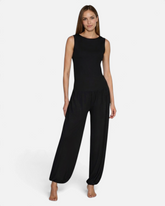 Model trägt schwarze greenyogashop Wide Pants aus Bambusviskose mit elastischem Bund und Bündchen am Bein