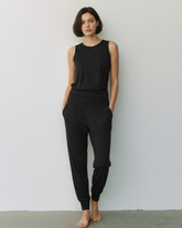 Model trägt schwarze greenyogashop Yogahose Flow aus Bambusviskose mit gerafftem Bund und Bündchen am Knöchel