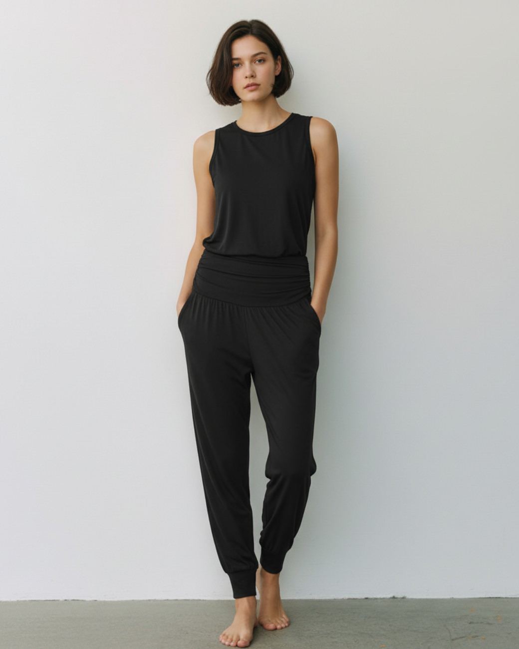 Model trägt schwarze greenyogashop Yogahose Flow aus Bambusviskose mit gerafftem Bund und Bündchen am Knöchel
