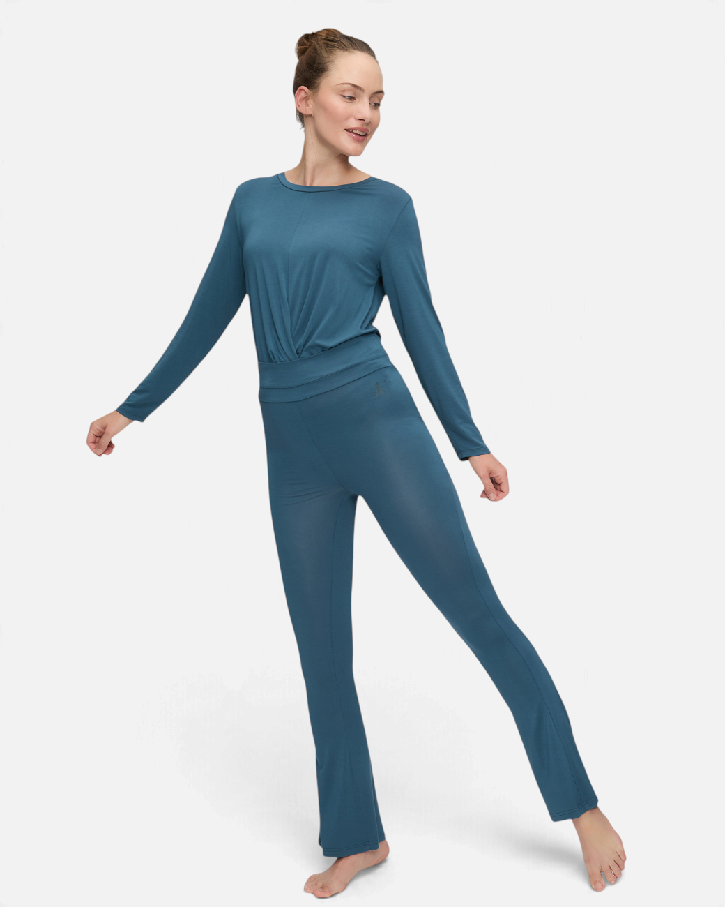 greenyogashop petrolfarbene Bootcut-Yogahose aus Bambusviskose mit breitem Umschlagbund an einer Yoga-Praktizierenden