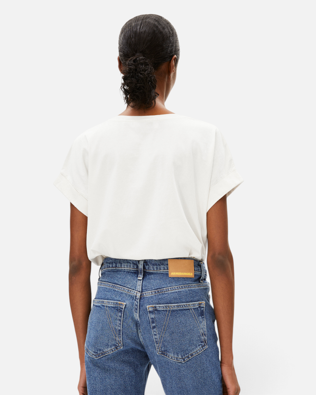 Rückansicht des weißen greenyogashop T-Shirt IDAARA aus Bio-Baumwolle mit lockerer Passform an einem Model