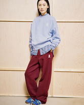 Model trägt greenyogashop ICONIC Å IVAARA Sweatpants in Velvet Red aus Bio-Baumwolle mit weitem Schnitt