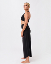 Model trägt schwarze greenyogashop Hose Roll Over Tulip in 7/8 Länge aus weichem Lyocell-Mix für Yoga und Freizeit