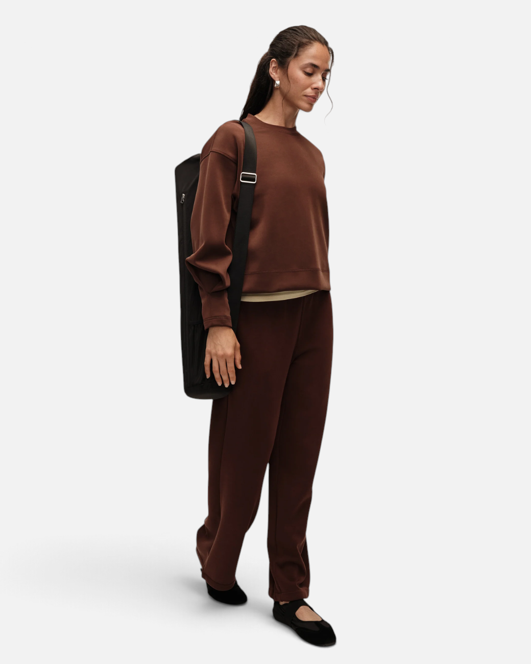 Model trägt dunkelbraunen greenyogashop Peachy Crew Neck Pullover mit voluminösen Ärmeln und passender Lounge-Hose