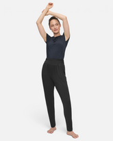 Model trägt eine schwarze greenyogashop Lockere Hose mit Umschlagbund und Tapered Leg aus weicher Bambusviskose