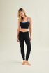 Woman wearing a black sports bra and sustainable black yoga pants styled for sustainable activewear fashion