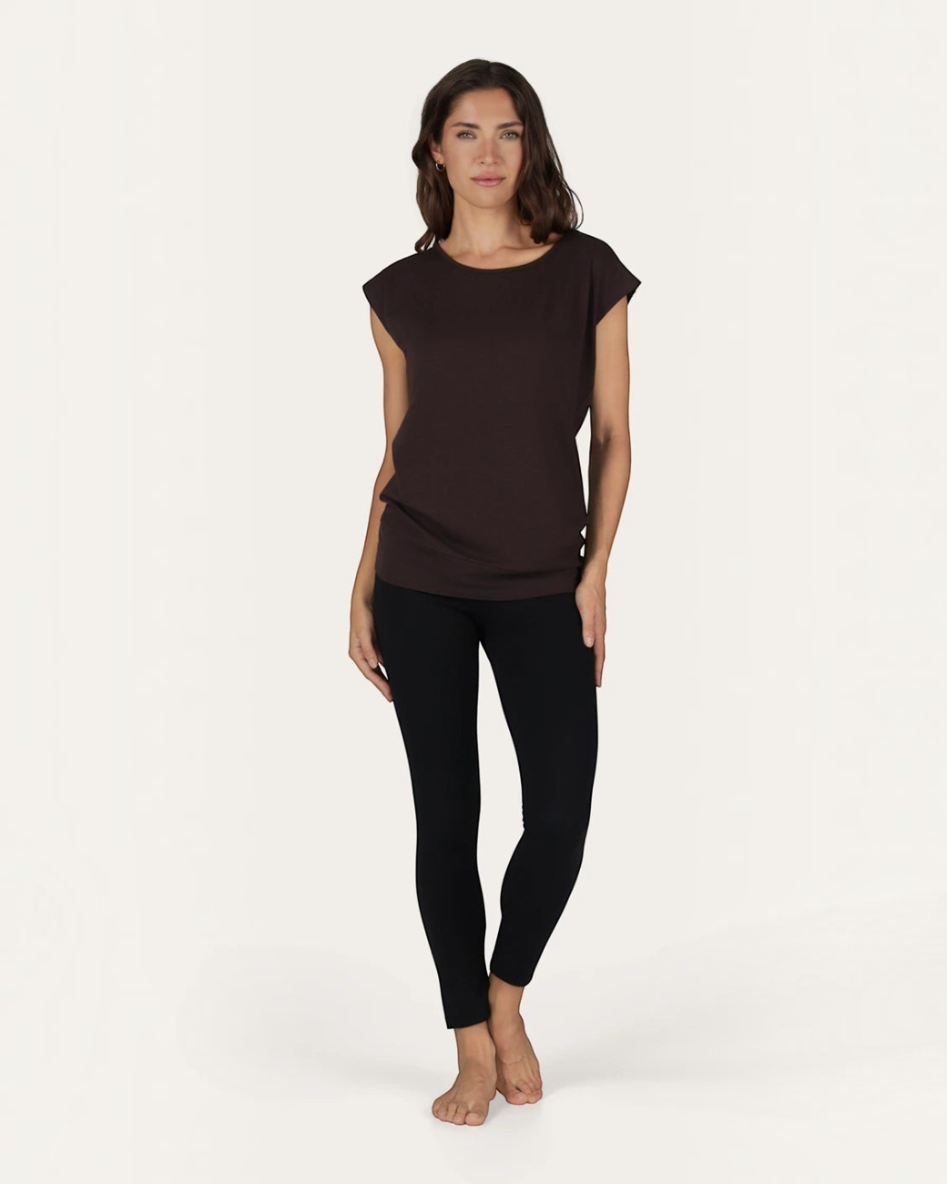 Model trägt das braune Asana Tee von greenyogashop aus weichem Bambus-Mix mit lockerer Passform und langem Schnitt.
