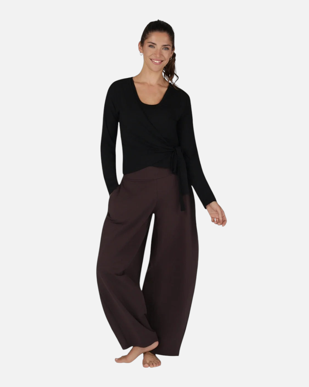 Model trägt die schwarze greenyogashop Aurora Wickeljacke aus weichem Bambus-Mix mit Bindeband für Yoga und Alltag.