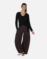 Model trägt die schwarze greenyogashop Aurora Wickeljacke aus weichem Bambus-Mix mit Bindeband für Yoga und Alltag.