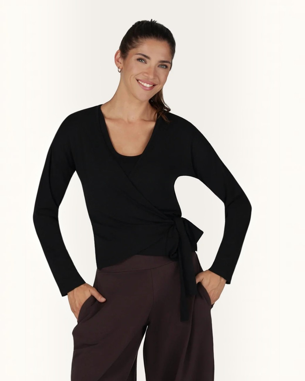 Model trägt schwarze greenyogashop Aurora Wickeljacke aus weichem Bambus-Mix mit Bindeband für Yoga und Alltag