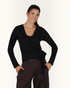 Model trägt schwarze greenyogashop Aurora Wickeljacke aus weichem Bambus-Mix mit Bindeband für Yoga und Alltag