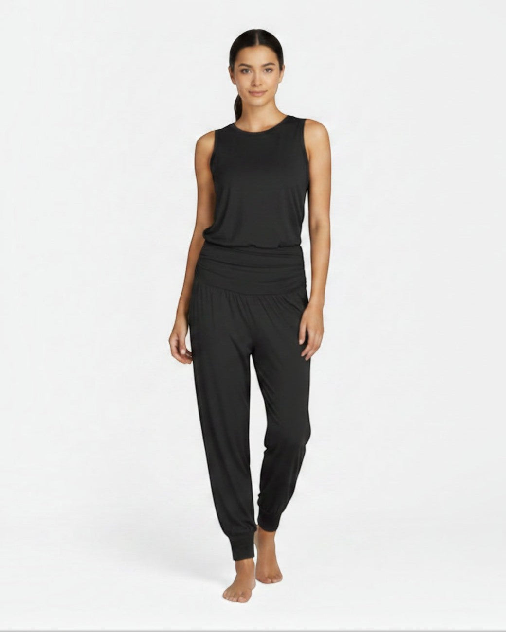 Model trägt schwarze greenyogashop Yogahose Flow aus Bambusviskose mit breitem Bund, Seitentaschen und Bündchen