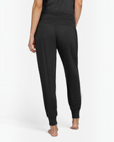 greenyogashop schwarze lange Yogahose Flow aus Bambusviskose mit breitem Bund und Bündchen am Bein, Rückansicht