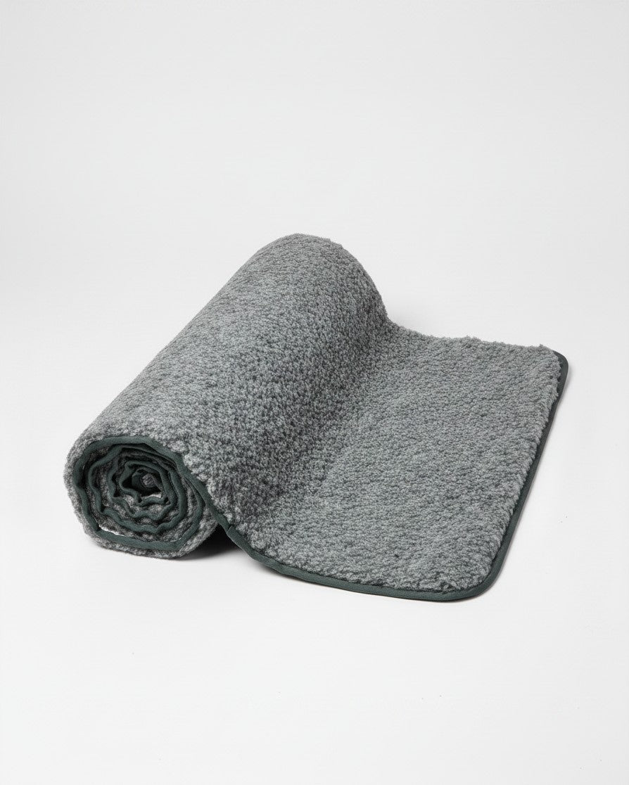 greenyogashop Yogamatte aus dunkelgrauer Wolle mit rutschfester Unterseite aus Naturlatex, halb aufgerollt