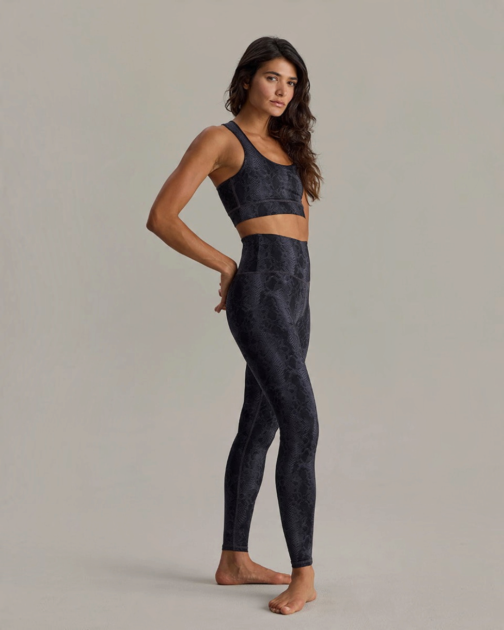 Model trägt greenyogashop Leggings mit Schlangenmuster und passendem Sport-BH aus feuchtigkeitsableitendem Material