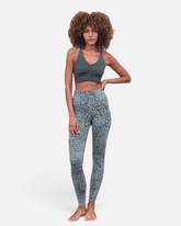 Model trägt greenyogashop Leggings Susan Animal in Aqua mit High-Rise Passform und Animal-Print aus Bio-Baumwolle